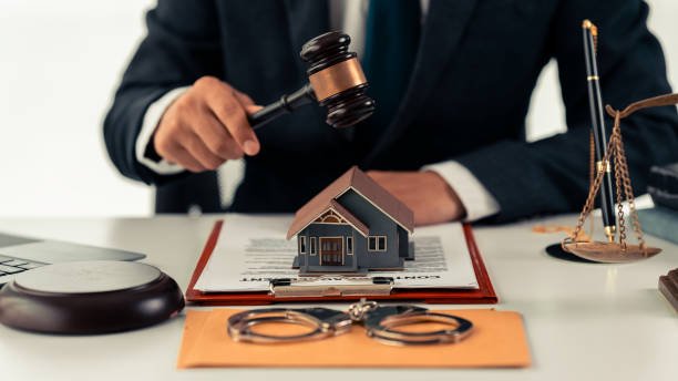 Hammer sitting on block in front of real estate